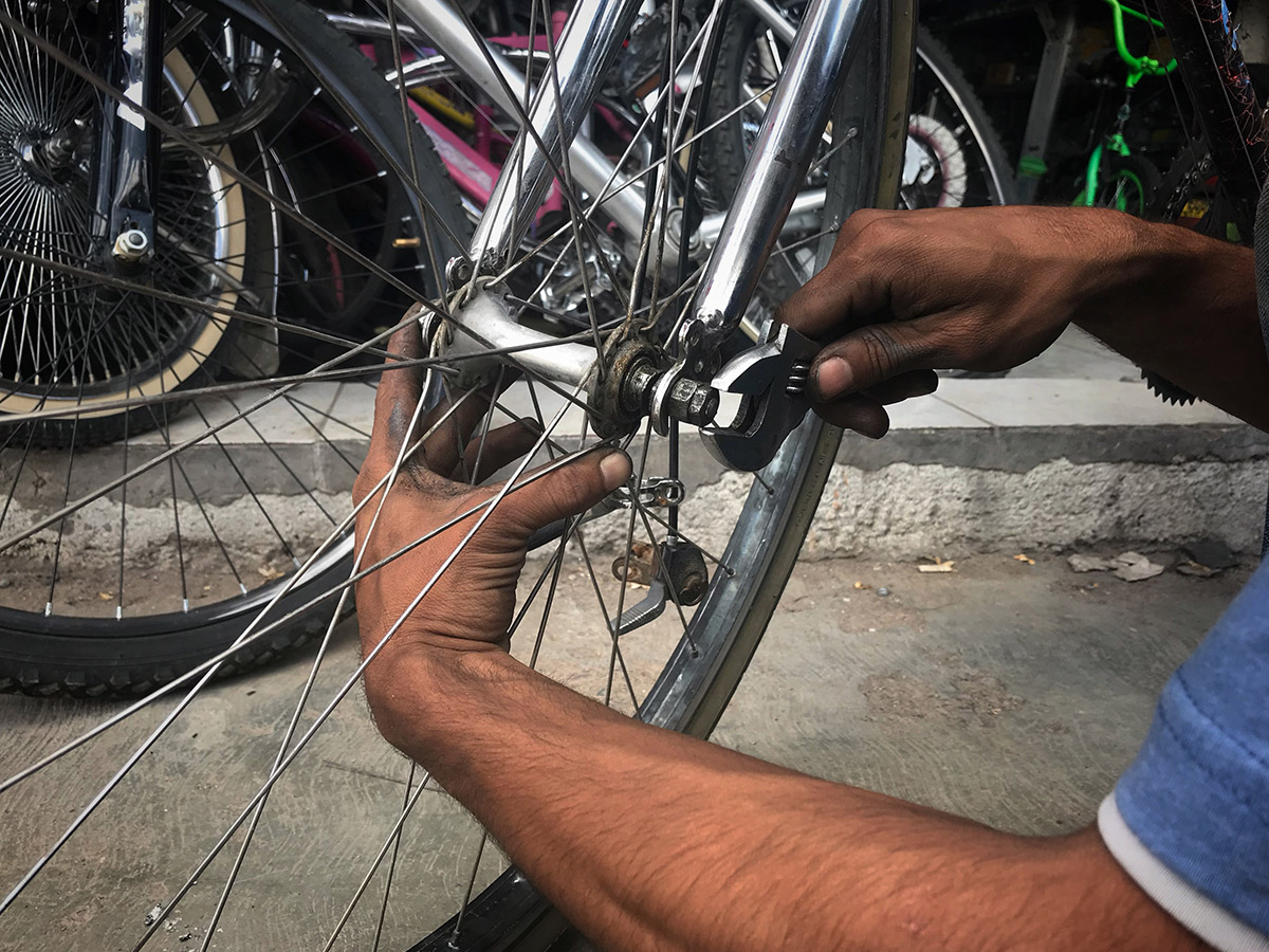 Jongman spring in om kinderhuiskinders se fietse te herstel